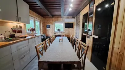 a dining room with a table and chairs in a kitchen at Ūdros slėnis in Bildžiai
