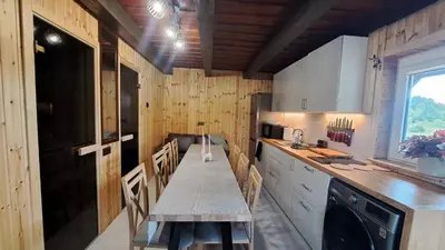 a kitchen with a table and chairs in it at Ūdros slėnis in Bildžiai