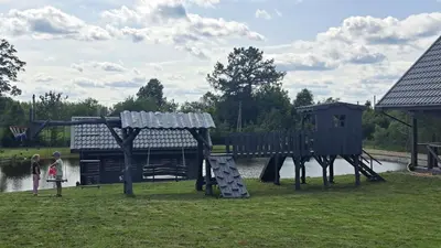 a childrens playground in a park next to the water at Ūdros slėnis in Bildžiai