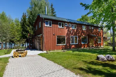 a red barn with a wagon in front of it at Sodyba Brazylija in Taraldžiai