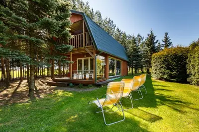 a group of chairs sitting in front of a house at Sodyba Brazylija in Taraldžiai