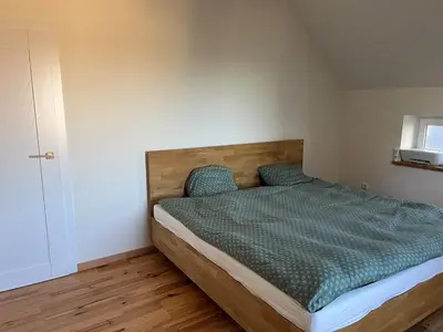 a bedroom with a bed with a green comforter at The cave in Vilnius