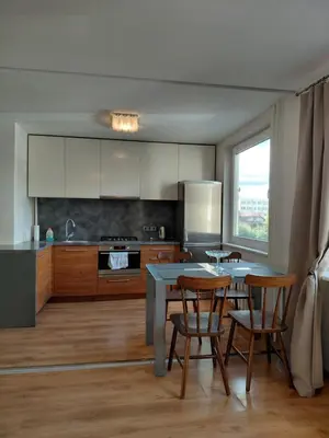 a kitchen with a table and chairs and a kitchen with a window at Two-Bedroom Flat Close to Downtown in Kaunas
