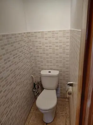 a bathroom with a toilet in a tiled room at Two-Bedroom Flat Close to Downtown in Kaunas
