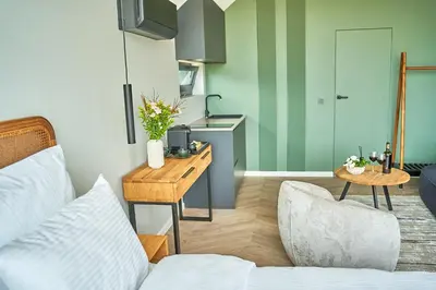 a living room with a bed and a table and a kitchen at Oriana Resort