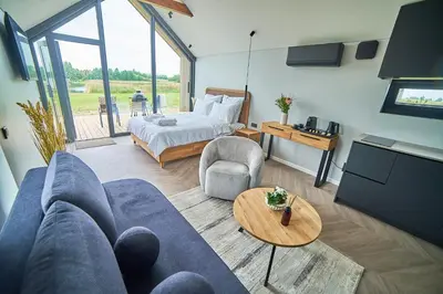 a living room with a blue couch and a bed at Oriana Resort