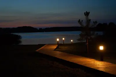 a wooden walkway with lights on the side of a lake at Oriana Resort