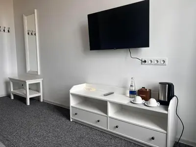 a white dresser with a flat screen tv on a wall at Arklių Pašto Stotis in Staškūniškis