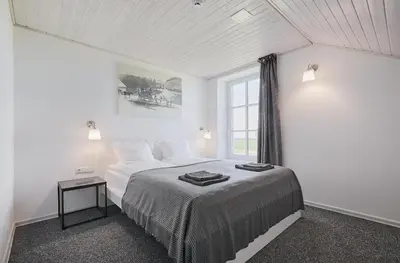 a white bedroom with a bed and a window at Arklių Pašto Stotis in Staškūniškis