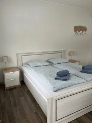 a white bed with two blue pillows on it at BHB Hotel in Marijampolė