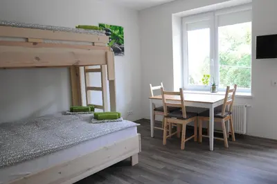a bedroom with a bed and a table and a bunk bed at BHB Hotel in Marijampolė