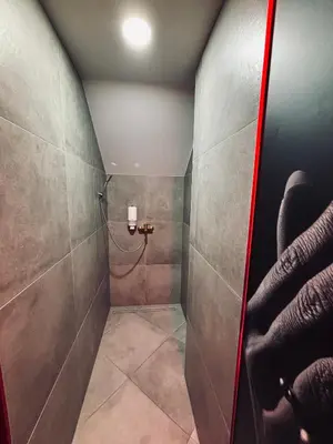 a bathroom with a shower with a glass door at 69 apartaments BDSM in Panevėžys