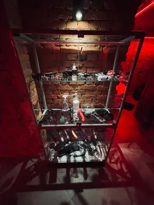 a glass display case in front of a brick wall at 69 apartaments BDSM in Panevėžys