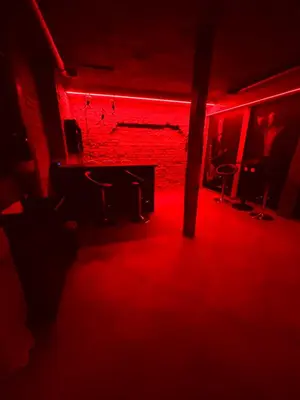 a red room with a table and chairs in front of a brick wall at 69 apartaments BDSM in Panevėžys