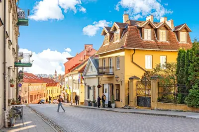 a cobblestone street in a city with buildings at Užupio Sparnai in Vilnius