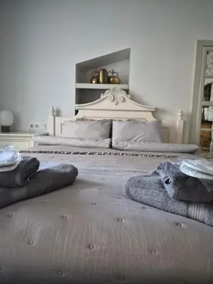 a white bedroom with a bed with a white headboard at Užupio Sparnai in Vilnius