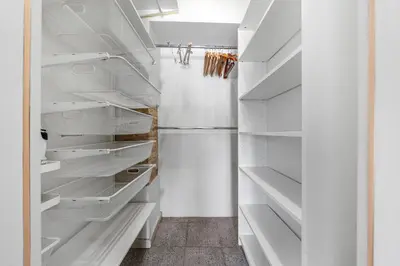 a white walk in closet with white shelves at Užupio Sparnai in Vilnius