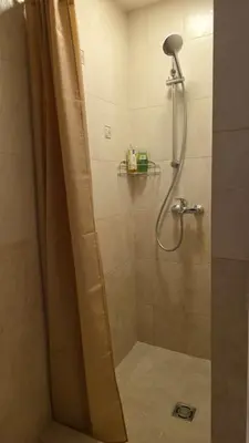a shower with a shower curtain in a bathroom at Vytauto Apartments in Šiauliai