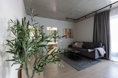 a living room with a couch and a plant at Modern 2 BDR Apartment next to Vilnius Outlet by URBAN RENT in Vilnius