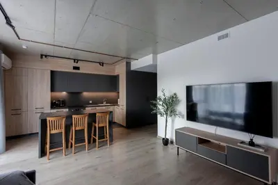 a kitchen with a table and chairs and a large television at Modern 2 BDR Apartment next to Vilnius Outlet by URBAN RENT in Vilnius