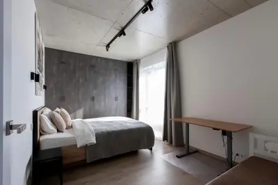 a bedroom with a bed and a desk in it at Modern 2 BDR Apartment next to Vilnius Outlet by URBAN RENT in Vilnius