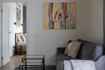 a living room with a couch and a painting on the wall at Modern 2 BDR Apartment next to Vilnius Outlet by URBAN RENT in Vilnius