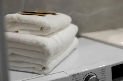 a pile of towels sitting on top of a microwave at Modern 2 BDR Apartment next to Vilnius Outlet by URBAN RENT in Vilnius