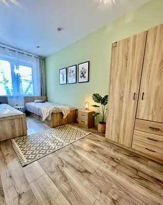 a bedroom with a bed and a large wooden door at Victoria Central Apartamentai in Druskininkai