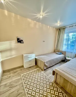 a bedroom with two beds and a rug at Victoria Central Apartamentai in Druskininkai