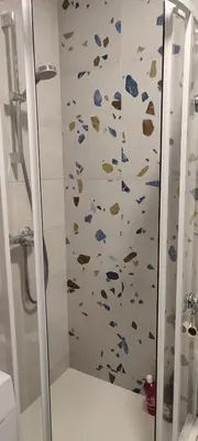 a bathroom with a shower with rocks on the wall at SimpleStayVilnius in Vilnius