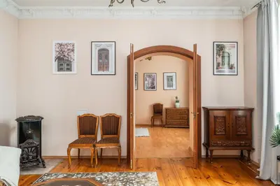 a living room with a mirror and two chairs at Heritage One Bedr Apartment by the Gates of Dawn by Reside Baltic in Vilnius