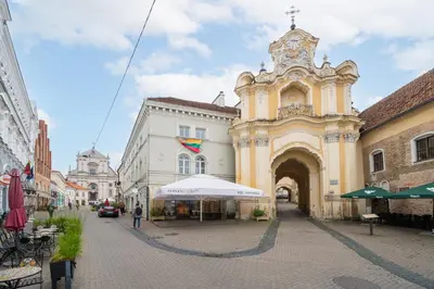 an old building with a clock tower on a street at Heritage One Bedr Apartment by the Gates of Dawn by Reside Baltic in Vilnius