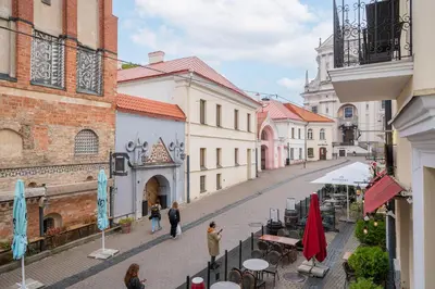 a group of people walking down a street with buildings at Heritage One Bedr Apartment by the Gates of Dawn by Reside Baltic in Vilnius