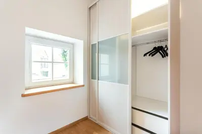 a walk in closet with a window and a mirror at Saint John Two Bedroom Cottage by Reside Baltic in Vilnius