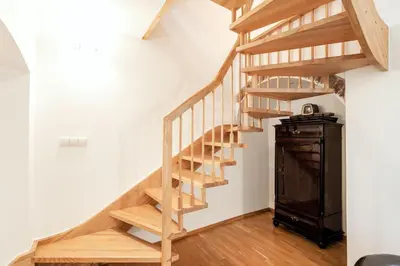 a wooden staircase in a room with a wooden cabinet at Saint John Two Bedroom Cottage by Reside Baltic in Vilnius