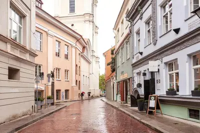 an empty city street in the rain with buildings at Saint John Two Bedroom Cottage by Reside Baltic in Vilnius