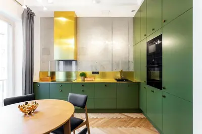a kitchen with green cabinets and a wooden table at Superior 2 Bedroom 2 Bathroom Apartment by Reside Baltic in Vilnius