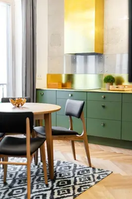 a kitchen with green cabinets and a table and chairs at Superior 2 Bedroom 2 Bathroom Apartment by Reside Baltic in Vilnius