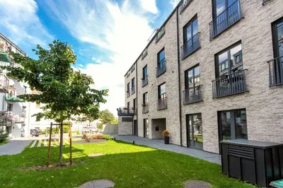 an apartment building with a green lawn in front of it at Superior 2 Bedroom 2 Bathroom Apartment by Reside Baltic in Vilnius