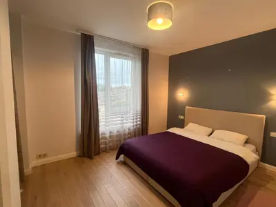 a bedroom with a bed and a large window at M27 Apartments in Vilnius