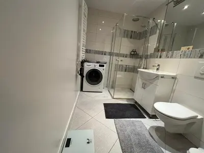 a bathroom with a washing machine and a washer at M27 Apartments in Vilnius