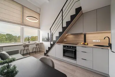 a kitchen with white cabinets and a staircase at Loft 10 in Vilnius