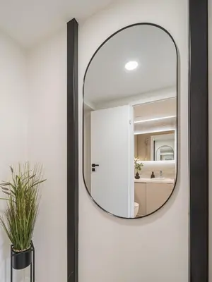 a round mirror on the wall of a bathroom at Loft 10 in Vilnius
