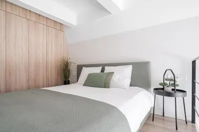 a bedroom with a large bed and a wooden wall at Loft 10 in Vilnius