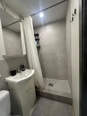 a small bathroom with a sink and a shower at Little cocoon at border of old city in Vilnius