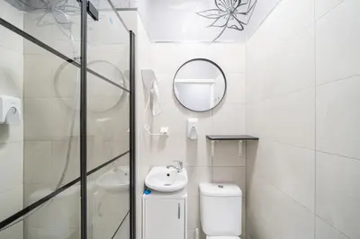 a white bathroom with a sink and a mirror at Sodų 17 Self Check-in - Lollo Stay in Vilnius