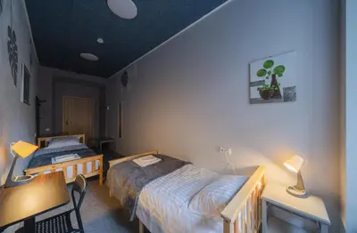 a bedroom with two beds and a table and a desk at Sodų 17 Self Check-in - Lollo Stay in Vilnius