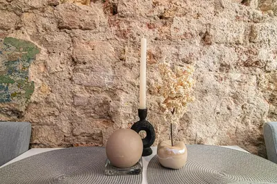 a table with a candle and two vases on it at Cozy flat in Vilnius Old Town in Vilnius
