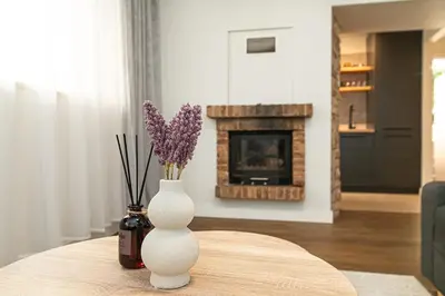 a white vase with flowers on a table in a living room at Cozy flat in Vilnius Old Town in Vilnius