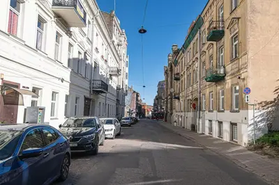 a street with cars parked on the sides of buildings at Cozy flat in Vilnius Old Town in Vilnius